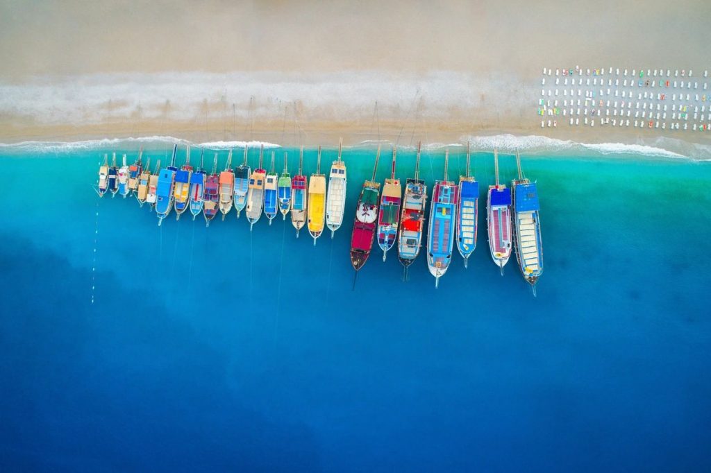 Aerial photo of colourful boats by a beach