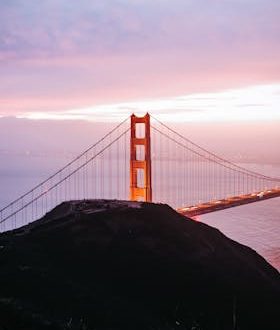Stunning aerial view of the Golden Gate Bridge at sunset with vibrant sky in San Francisco, California.