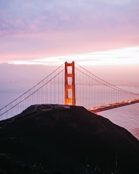 Stunning aerial view of the Golden Gate Bridge at sunset with vibrant sky in San Francisco, California.